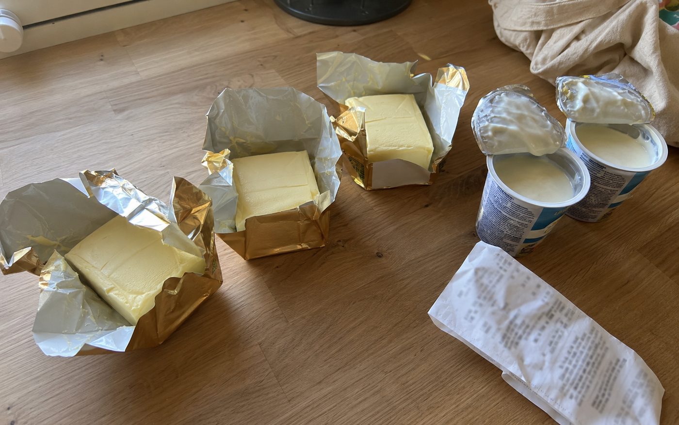 Drei angebrochene Butterpackungen und doppelte Joghurts auf der Arbeitsplatte